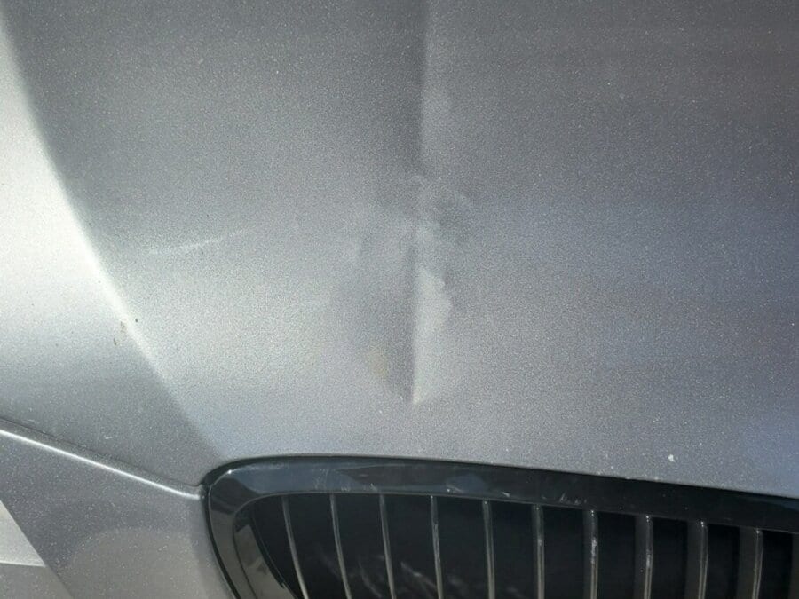 BMW hood with clearcoat stressed and high spots from sharp PDR tool pushed with too much force