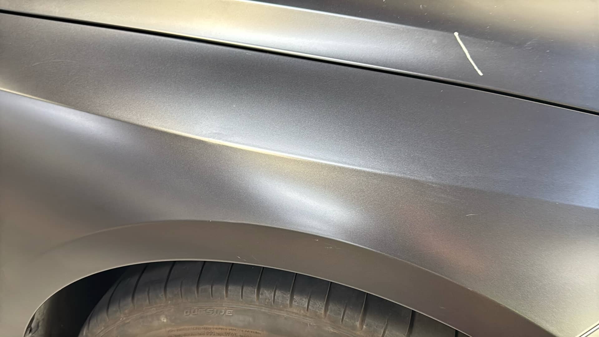 The same matte BMW fender after paintless dent repair, the body line restored
