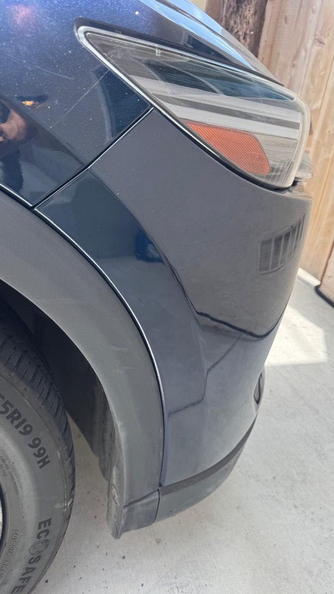 The same dark blue SUV fender and wheel arch trim after scrape and paint repair in Escondido