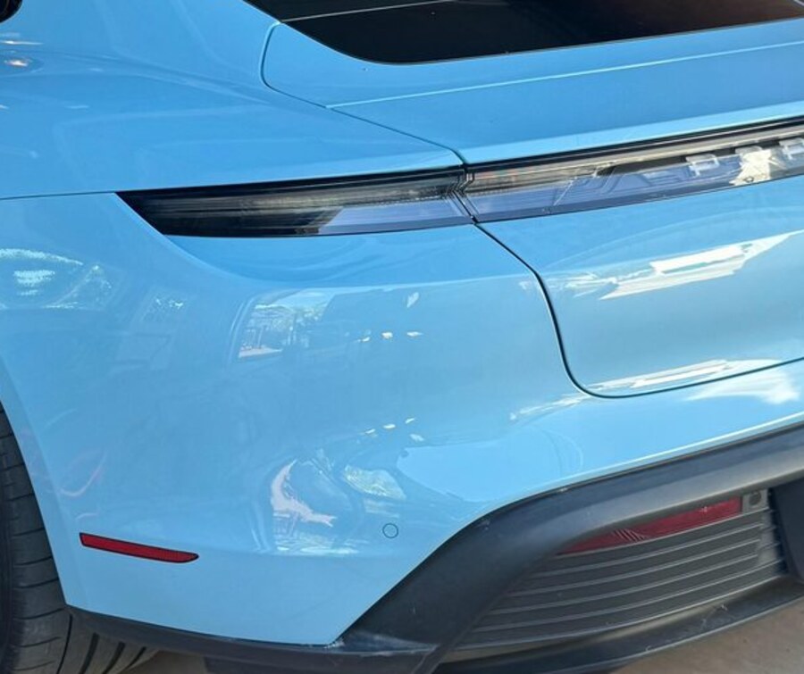The same Porsche Taycan rear quarter after mobile refinish, the scrape gone and the factory colour matched